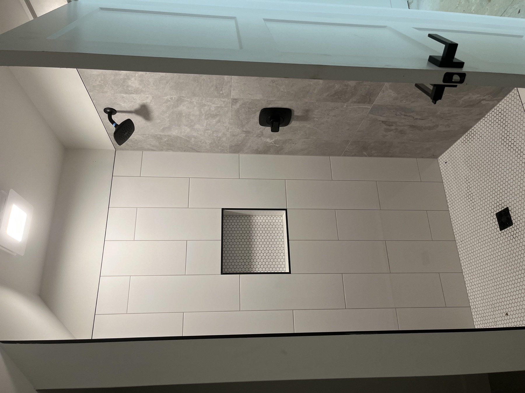 Walk-in shower · hex floor & black fixtures