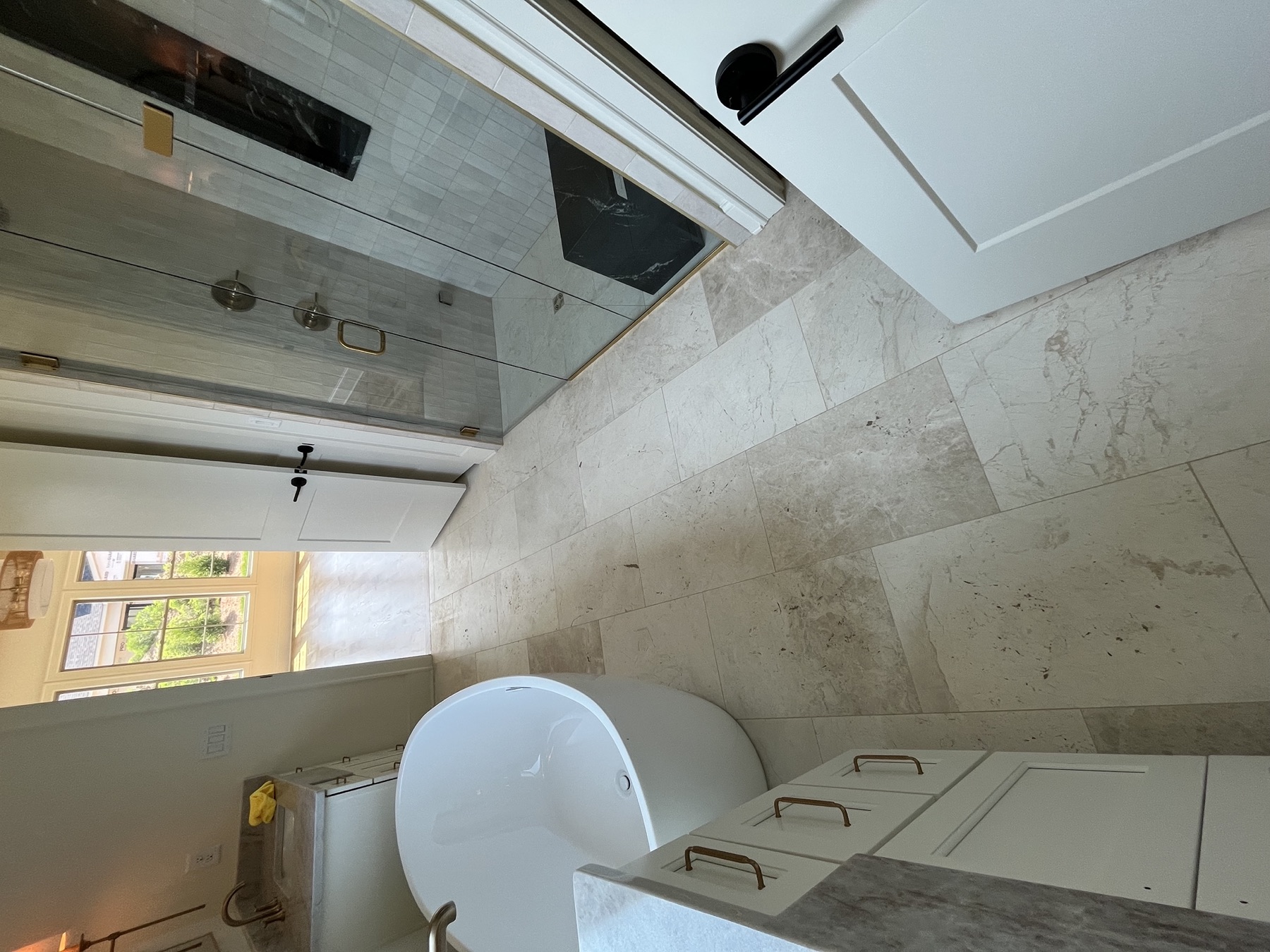Chattanooga bathroom remodel with stone floor tile, glass shower, and freestanding tub