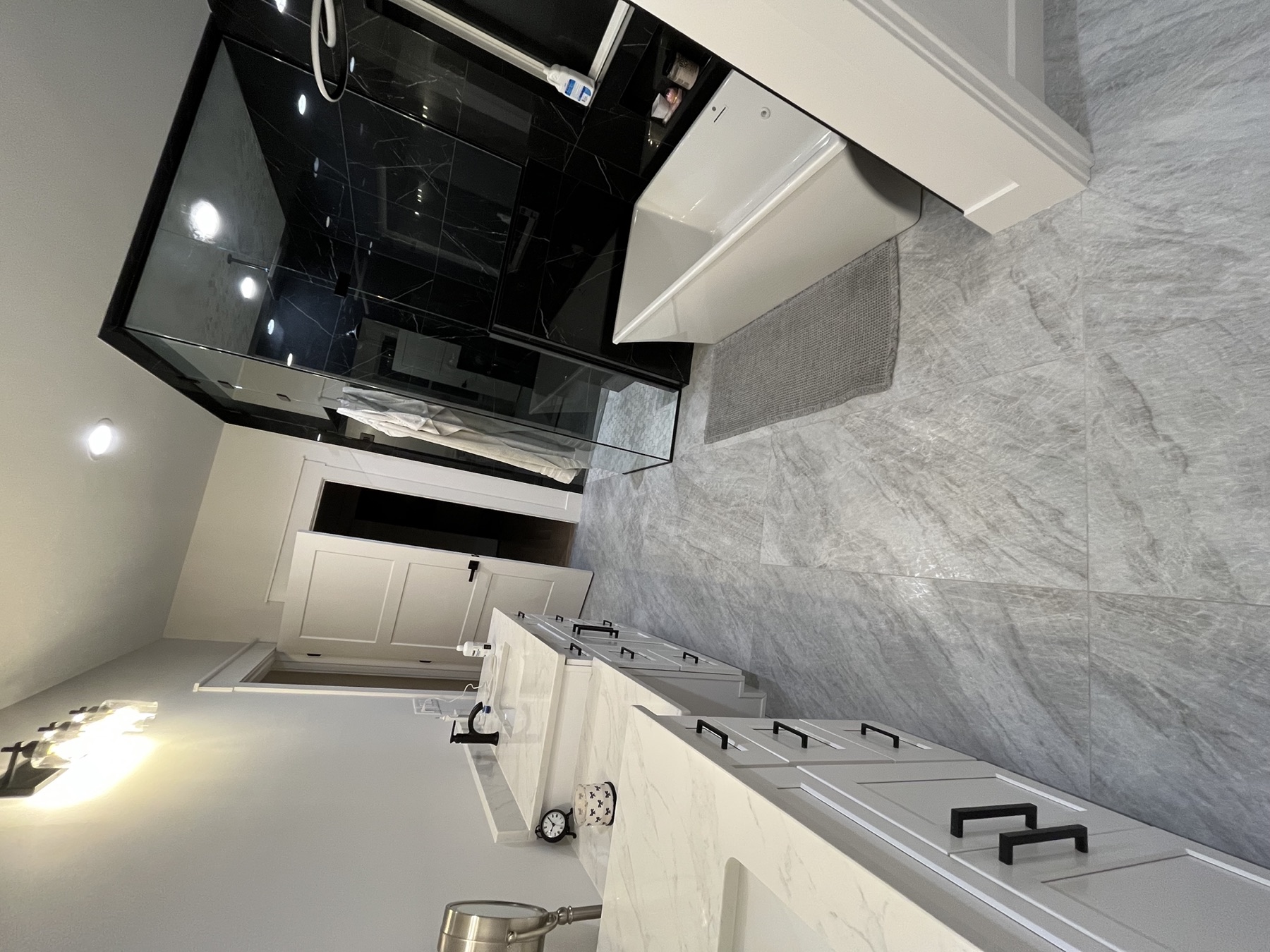 Finished bathroom remodel with double vanity, floor tile, and dark marble shower